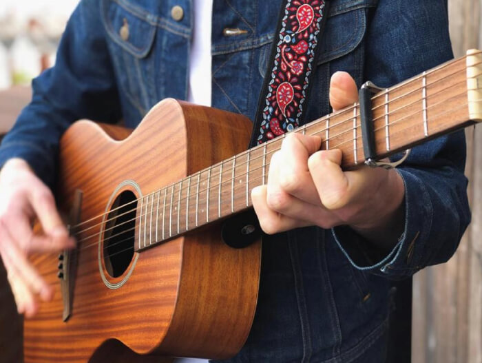 person holding acoustic guitar